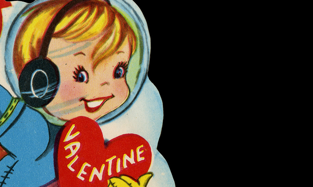 Feature image close-up of World War I era valentine card shows boy holding heart that says VALENTINE