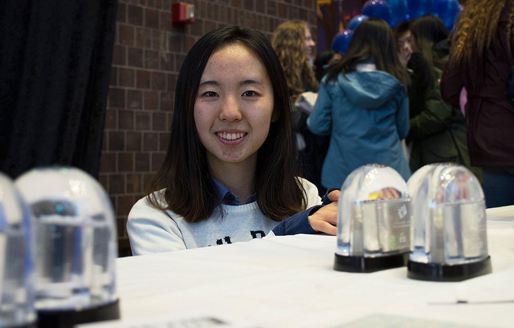 student poses with snowglobes