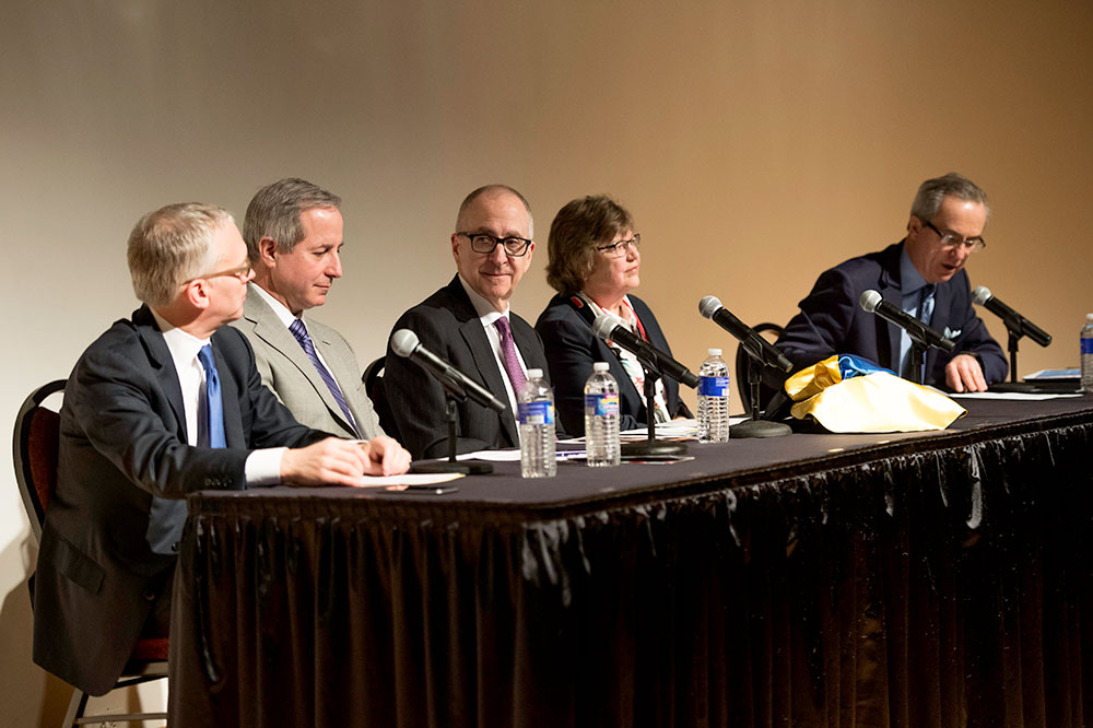 panel of people at a table, with microphones