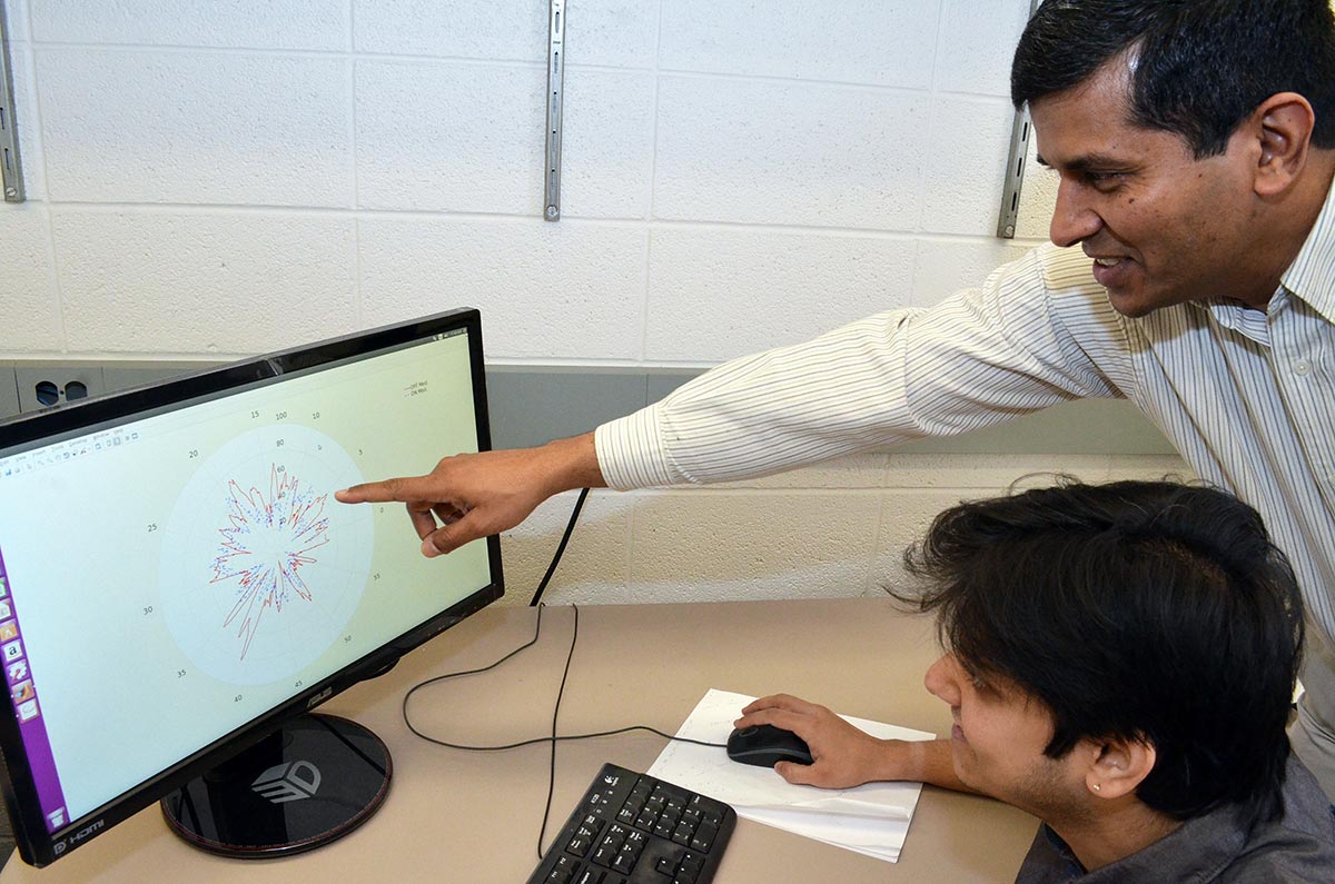 two researchers looking at data on computer screen