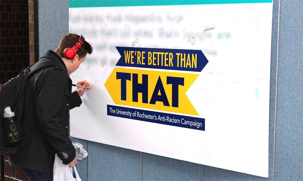 Feature image student signing a "We're Better Than That" poster