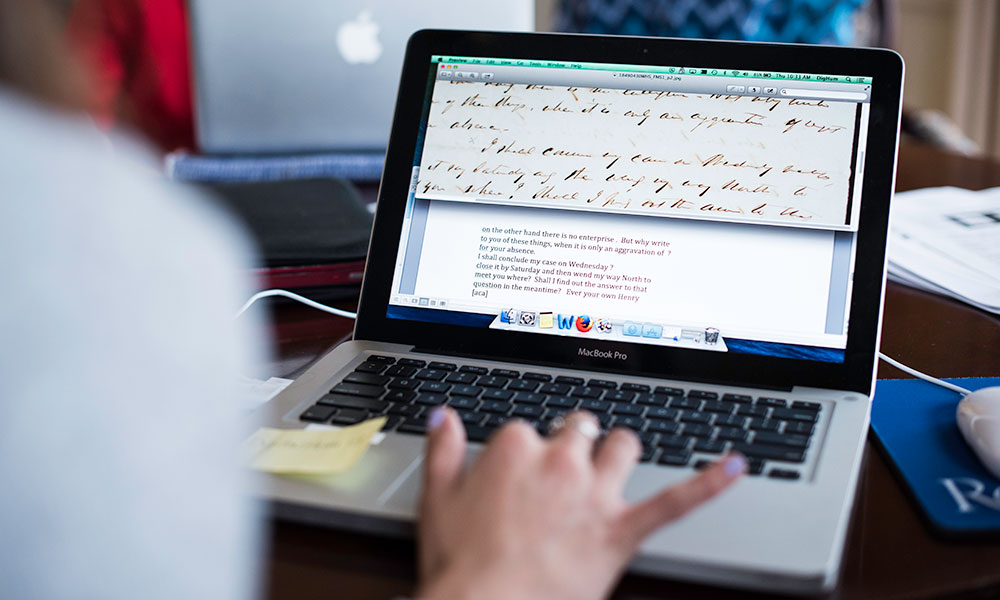 Feature image woman at laptop, screen showing handwritten document with typed transcript
