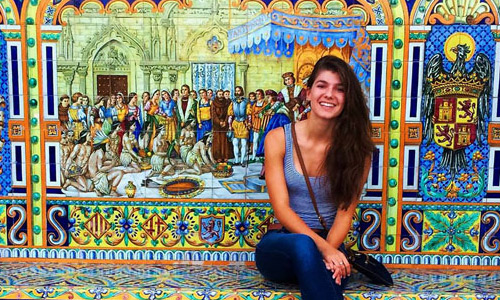 Feature image woman in front of elaborate mural