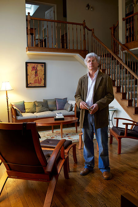 man standing in library in his home