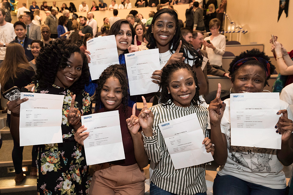 group of students hold up letters