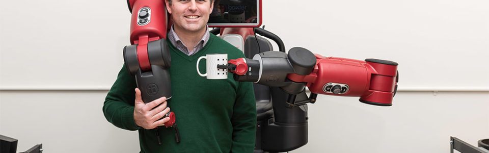 man with robot holding a coffee cup in front of him