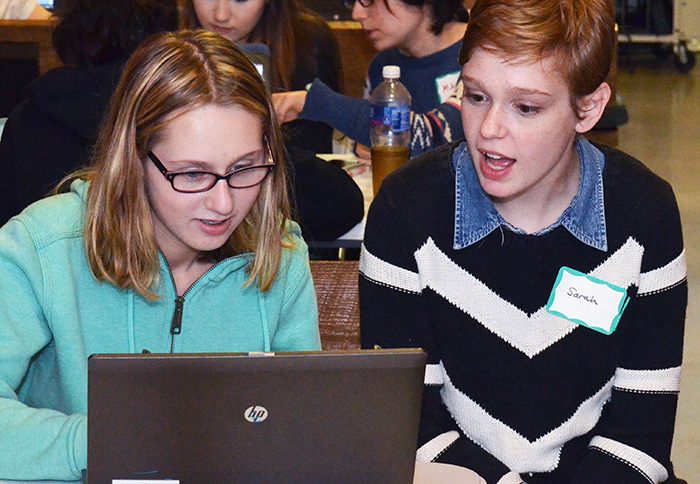 student helping another student at the laptop