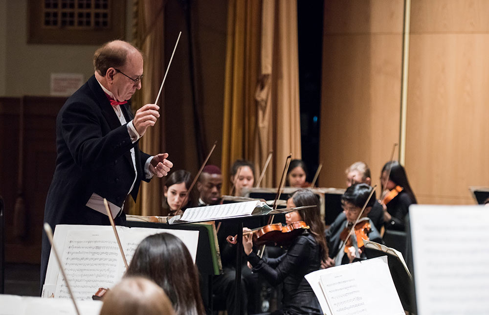 Feature image man in coat and tails conducting an orchestra