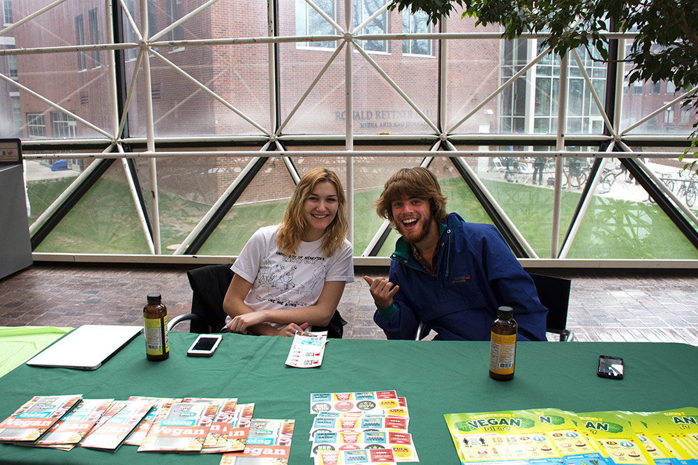 Two students with brochures at a table