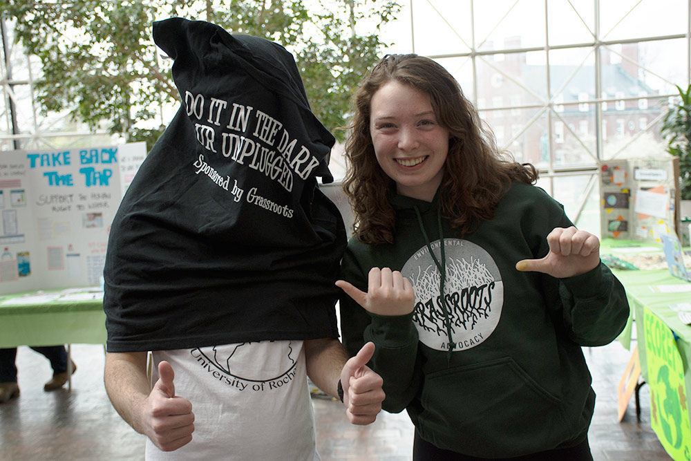 Two students, one with a hoodie over his head, with thumbs up