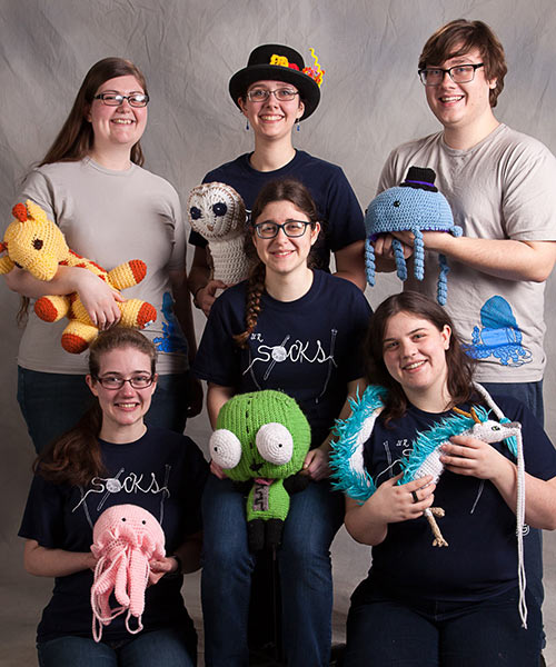 students with toys made of yarn