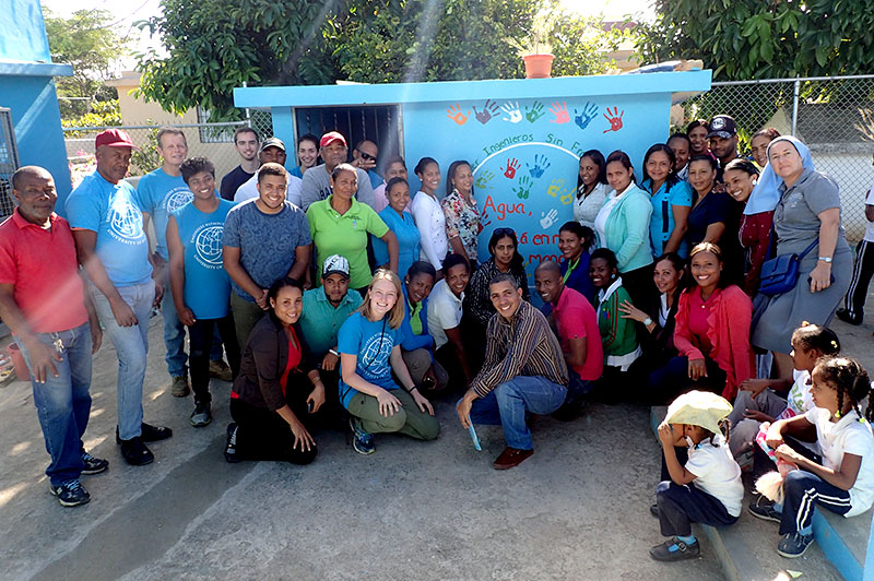 large group portrait in front of brightly painted building