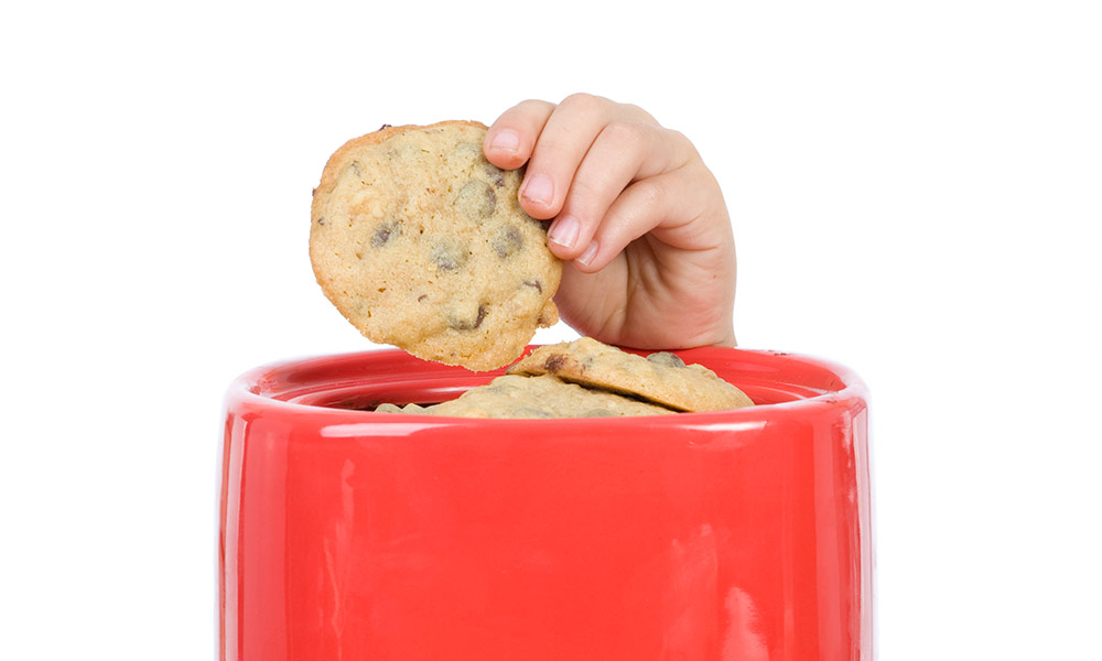 child with hand in cookie jar