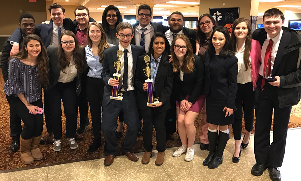 Feature image large group of students celebrating with trophies