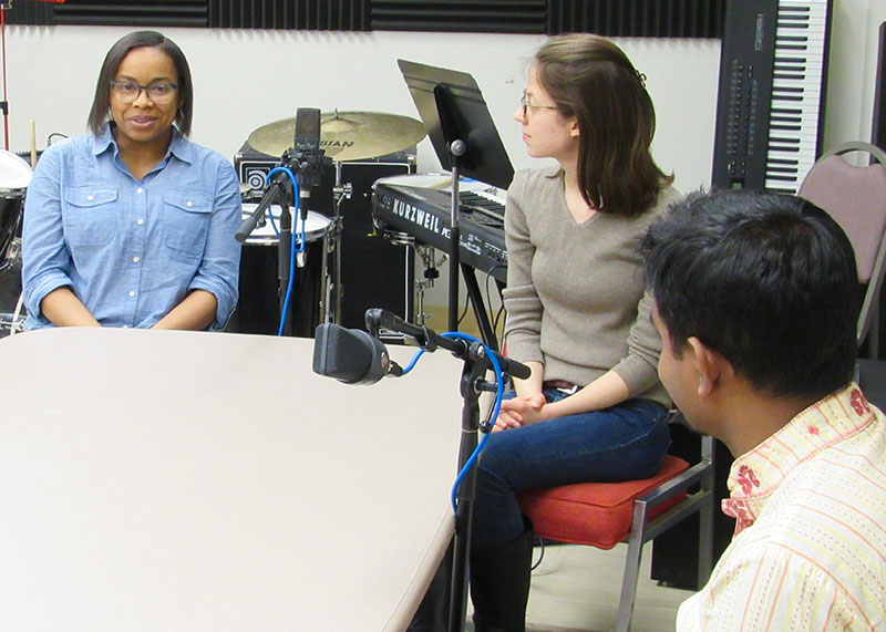 students sitting at a table around a microphone