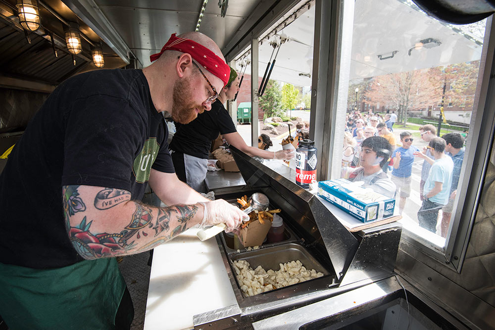 man scooping up fries in a food truck