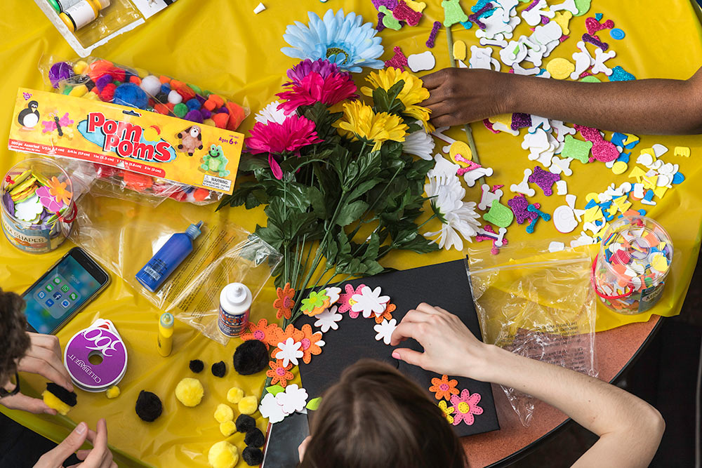 students around a table decorating mortarboards