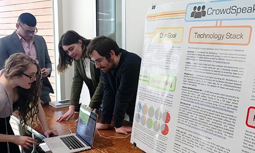 students with laptop and posters