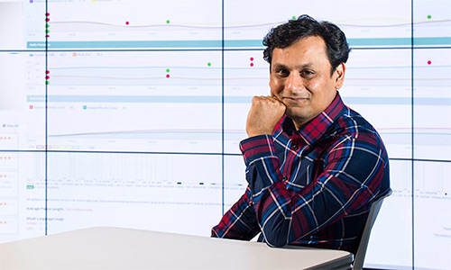 Ehsan Hoque in front of data on a large screen