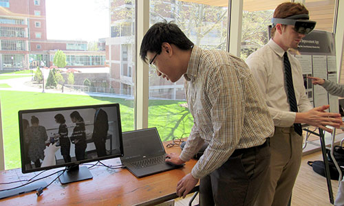 student looking at screen and another wearing virtual reality goggles