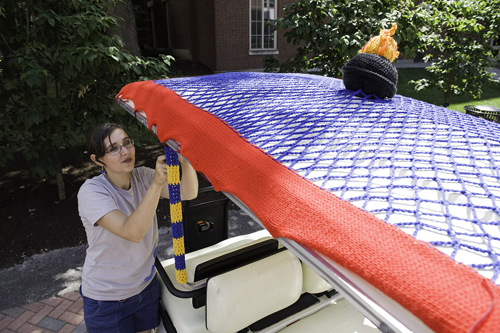 student crochets on golf cart
