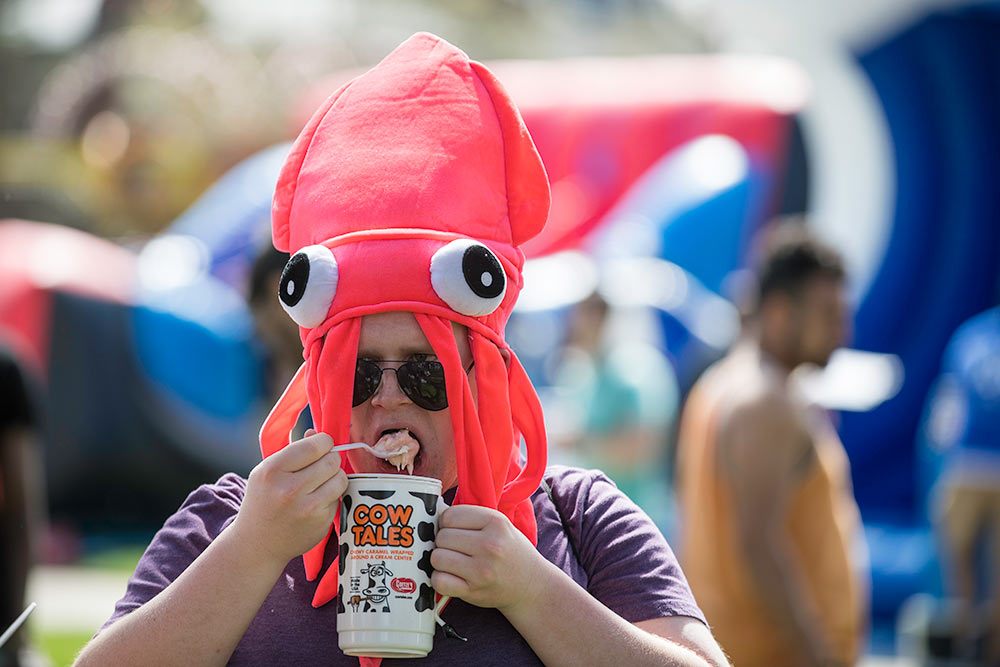 man eating ice cream wearing a squid hat