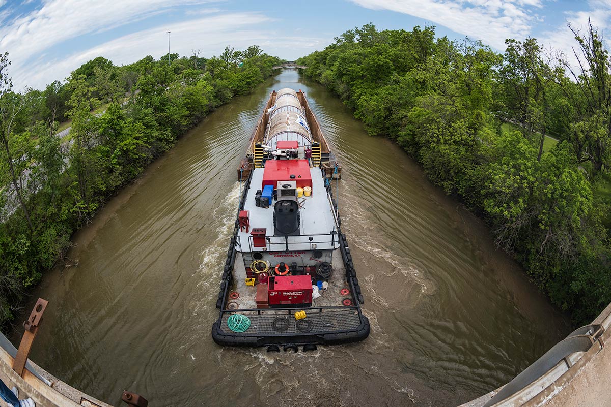 large barge in the Erie Canal holds three very large tanks