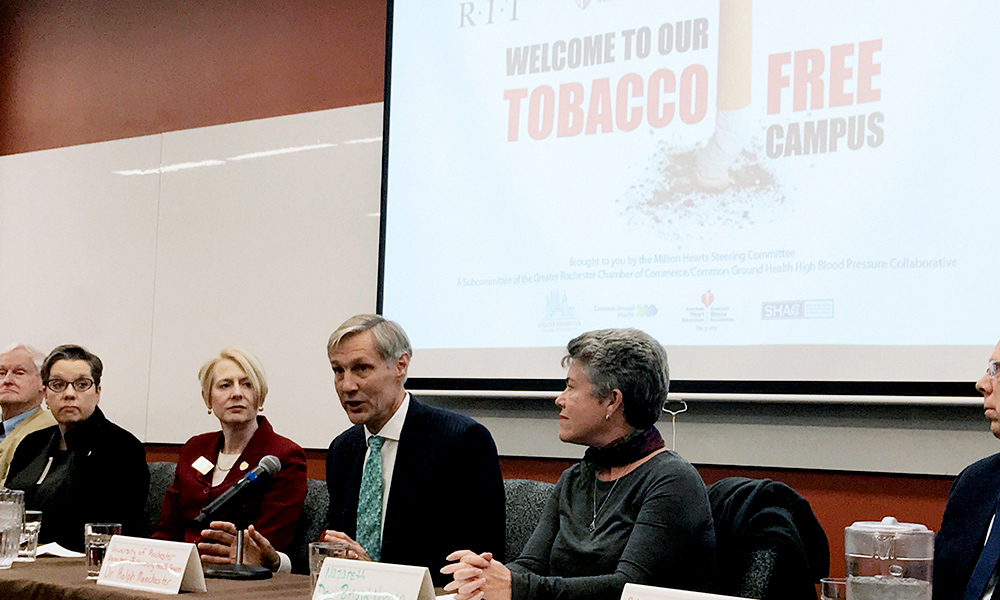 Feature image four people speaking at a panel, with screen behind that reads TOBACCO FREE CAMPUS