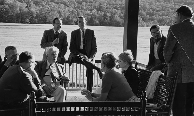 archival image of Bread Loaf conference writers, including poet RObert Frost, sitting outside near a lake