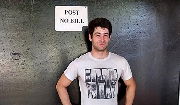 man standing in front of a sign that reads POST NO BILL