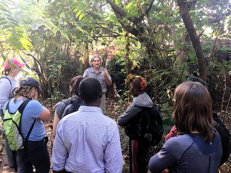 large group of students surround their instructor