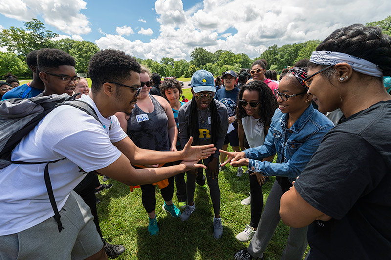 large group of students playing rock paper scissors