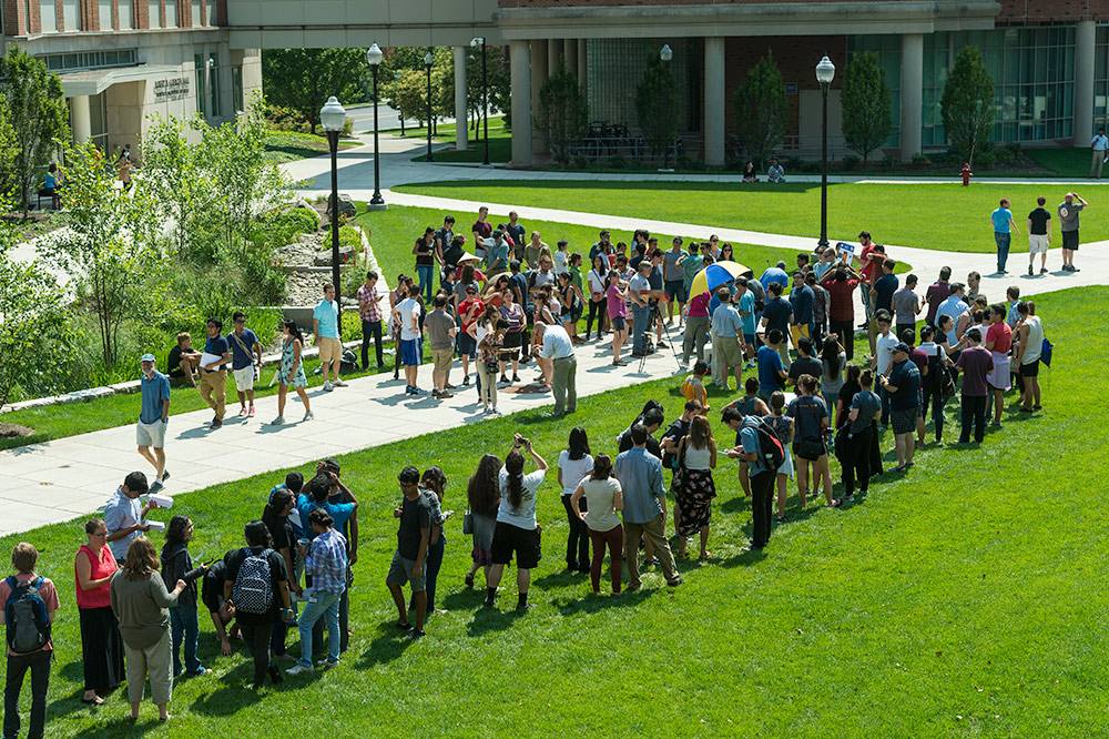 long line of people waiting on the quad