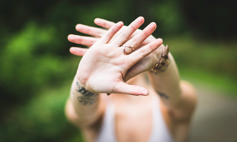 Feature image woman holding hands in front of her face