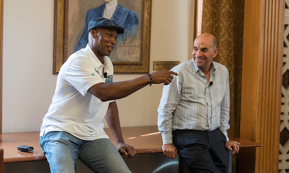 Feature image two men smiling and talking to an audience