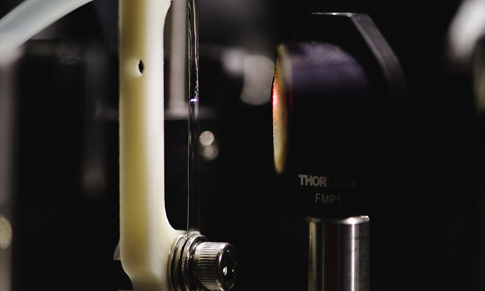 laser shining a pulse of light onto a thin film of water