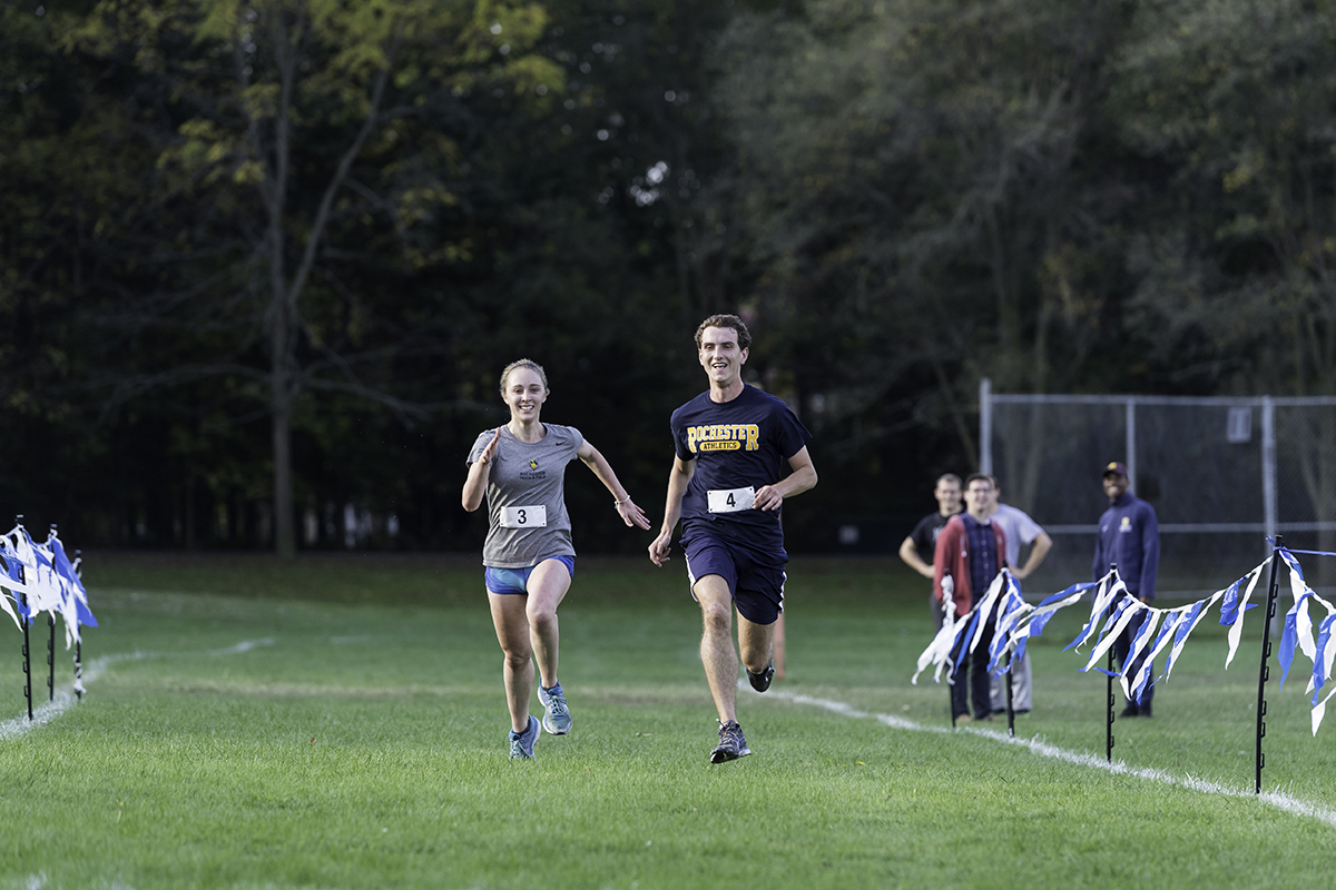 man and woman sprinting in a race in a park