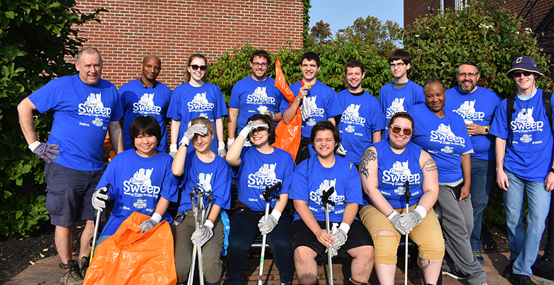 group photo of people in matching t-shirts and shovels and bags)