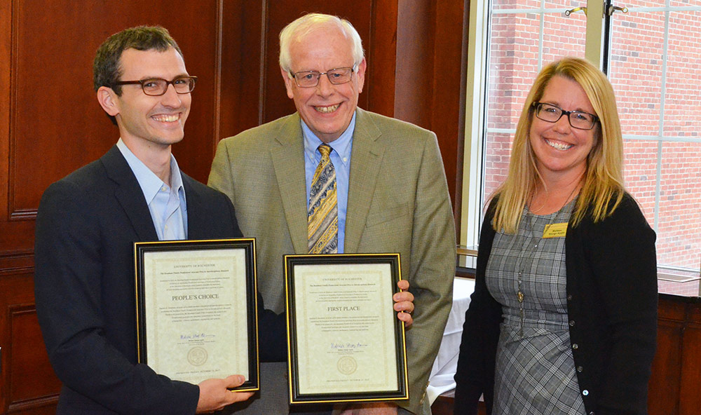 three people pose with award certificates