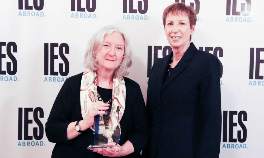 Feature image two women pose for a phone, one holds an award