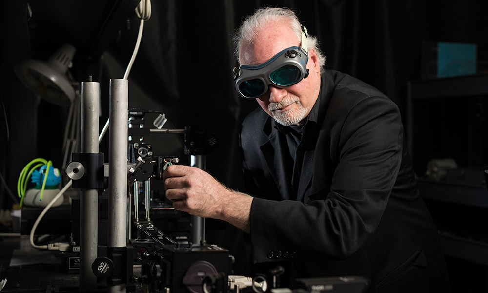 Wayne Knox wearing goggles in his optics lab