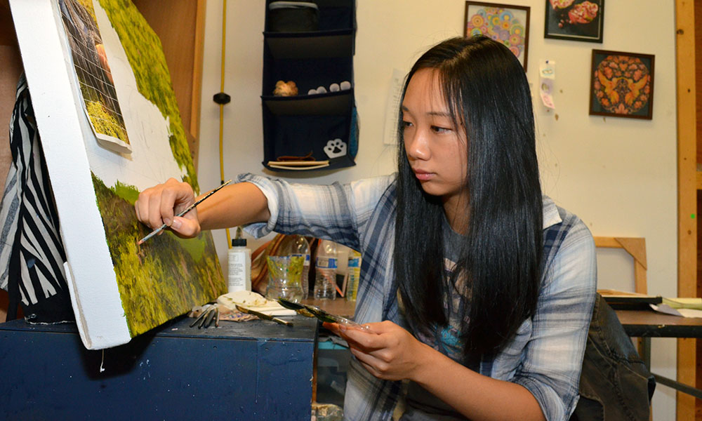Feature image student working on a painting