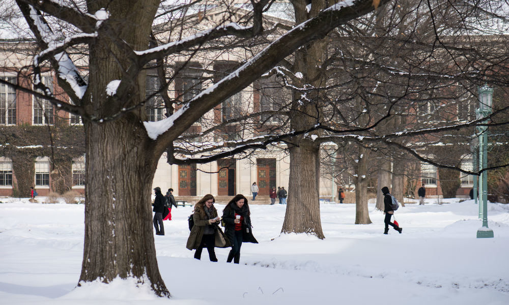 People walk across a snowy Eastman Quadrangle, part of the University's StormReady campus.