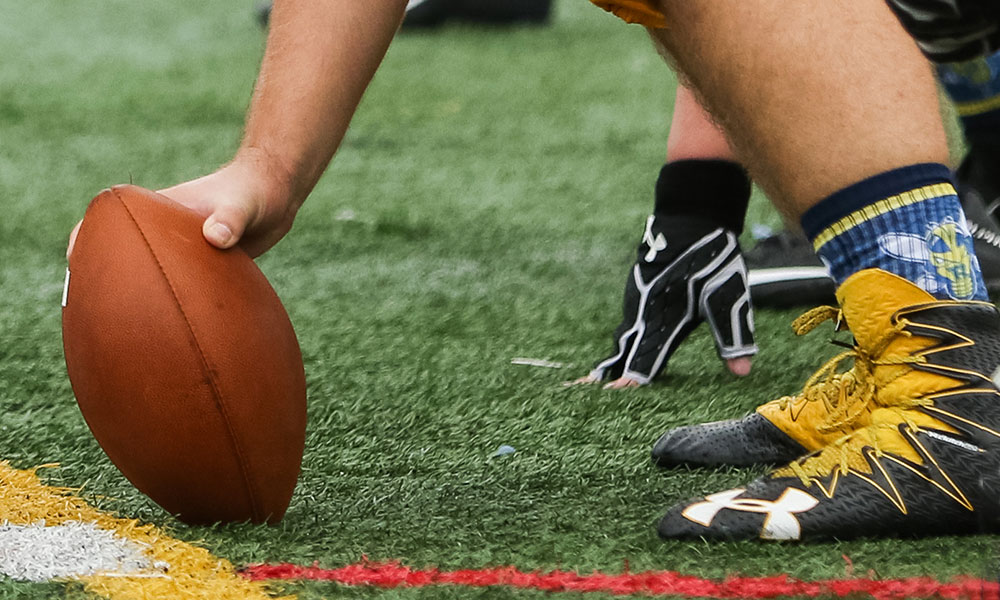 Feature image football set up for a "hike" in a Yellowjackets game
