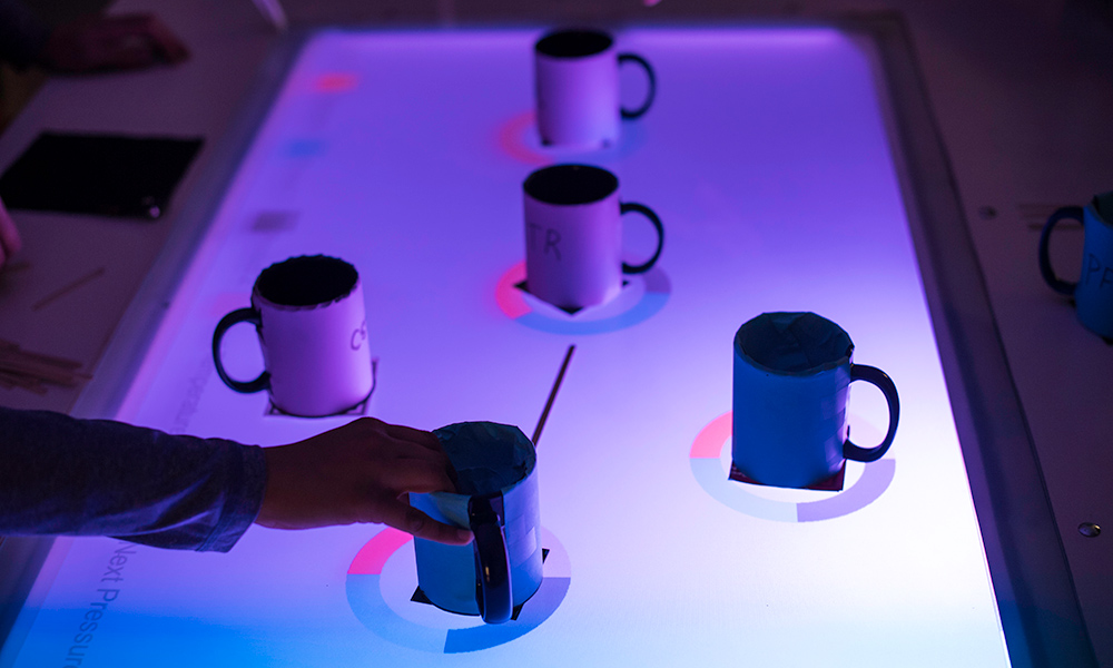 lighted glass table covered in coffee mugs