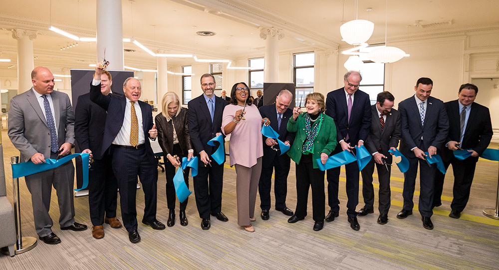 line of people cutting a ribbon at NextCorp grand opening