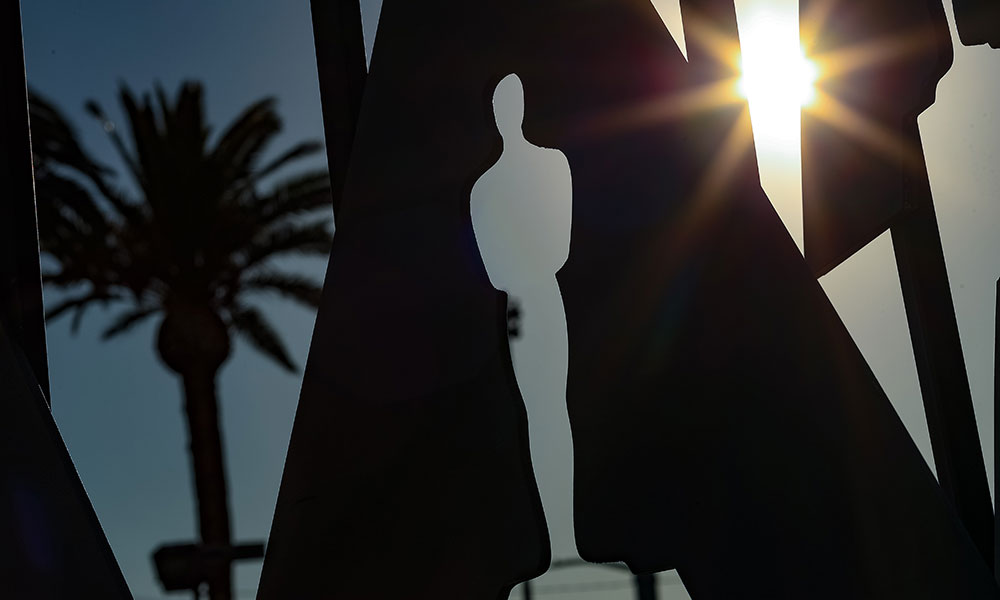 Oscars status against Hollywood skyline with sunshine and palm trees