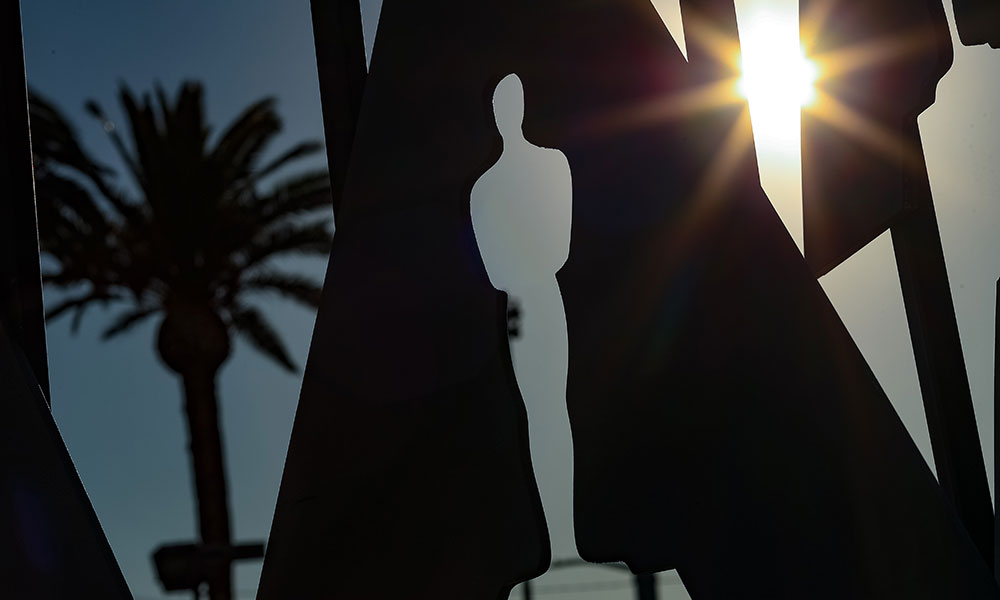 Feature image Oscars status against Hollywood skyline with sunshine and palm trees