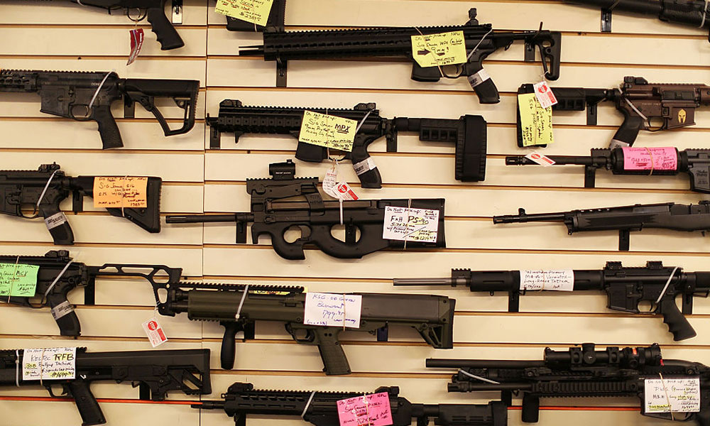Feature image wall display in a gun store shows lots of guns
