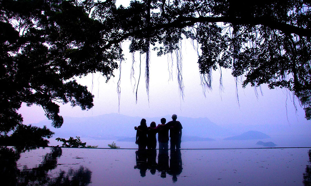 fous students standing arm-in-arm looking at a sunset